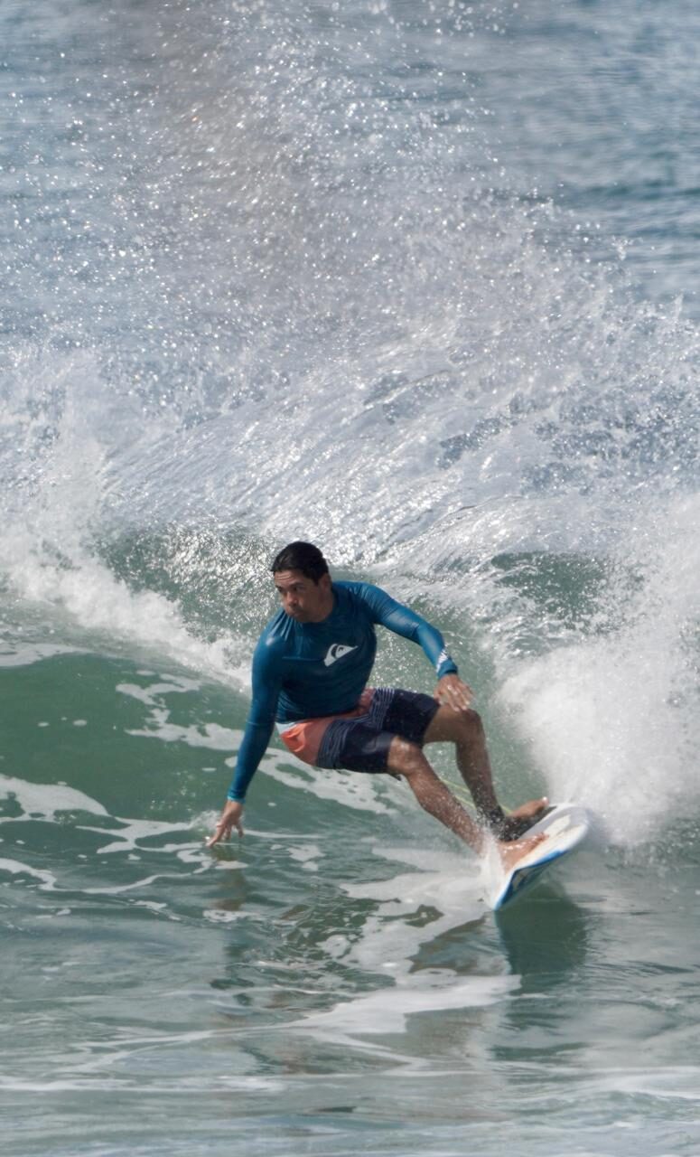 Surfista haciendo una maniobra en la ola