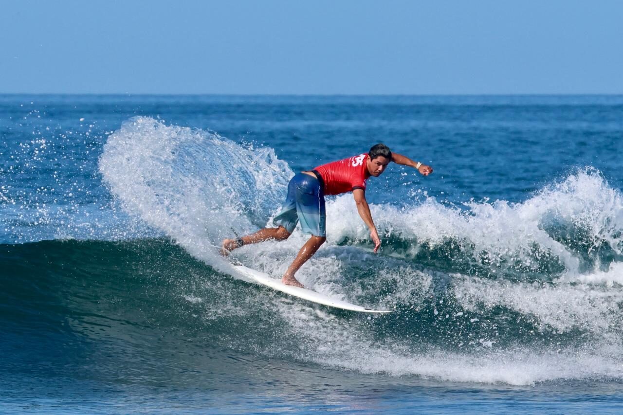 Surfista corriendo una ola
